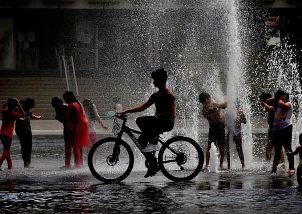 Children play in the water fountains at City Park, Bradford. PIC: Simon Hulme