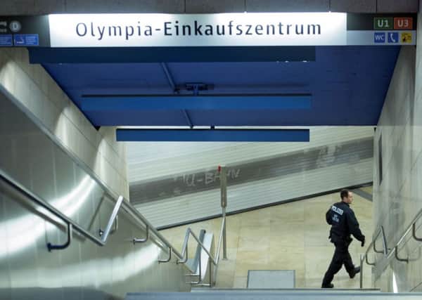 A policeman checks a closed metro station near the the scene of a shooting in Munich, Germany.