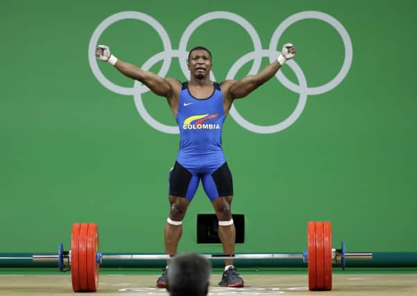 Colombia's Oscar Albeiro Figueroa Mosquera celebrates after winning the gold medal in the men's 62kg weightlifting competition.