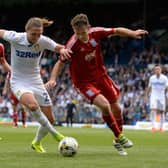 Luke Ayling is challenged in the box by Jonathan Grounds.