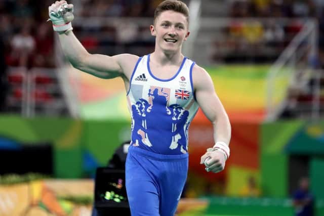 Nile Wilson punches the air after nailing his high bar routine (PA)