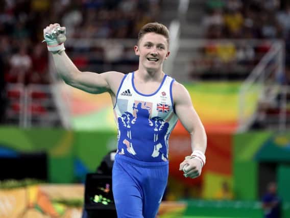 Nile Wilson punches the air after nailing his high bar routine (PA)