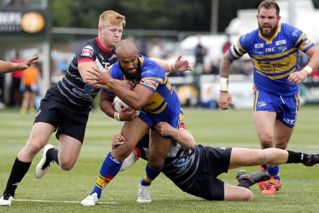 Leedsd Rhinos' Jamie Jones-Buchanan escapes from the tackle of James Cunningham. Picture: Max Flego.