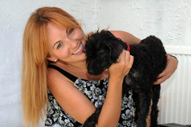 Victoria Elliot after being reunited with Scrappy the poodle in Wilford, Nottinghamshire. See News Team story NTIDOG; This is the adorable moment a dog was reunited with a family who were forced to give him up when his original owner died NINE years ago. Cute poodle Scrappy was adopted by gran Thelma Curzon two years before she died at the age of 84 in 2007. At the time her family were unable to look after the pooch because of work commitments so the dog was sent to live with family friends. But last week Nottingham City Council's stray dogs team found the matted poodle, who was not wearing a collar, roaming around the streets and took him to the pound. Incredibly, bosses were able to make contact with Mrs Curzon's relatives because 12-year-old Scrappy was still microchipped to his original owner. Adorable video footage captured the moment the dog went berserk as he recognised Mrs Curzon's daughter and granddaughter during an emotional reunion on Tuesday (23/8).