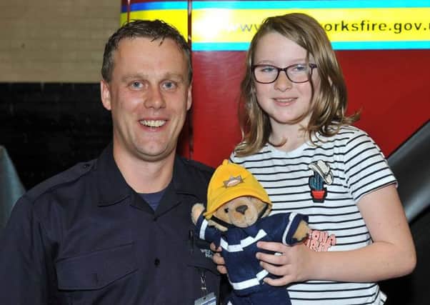 Firefighter David Cheesbrough with Isobelle McLennan, who was rescued from a house fire near Otley