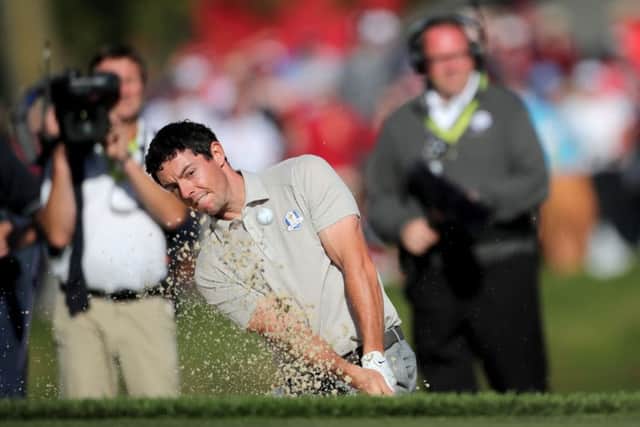 Europe's Rory McIlroy plays a shot from the bunker on the 14th.