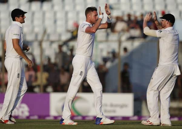 England's Stuart Broad, center, celebrates with Ben Stokes, right, and captain Alastair Cook, left, the dismissal of Bangladesh's Mehedi Hasan Miraz