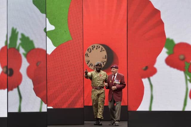 World War II veteran Geoffrey Pattinson (right), 92, stands with former RAF medic Ben Poku, 34, as they view a video installation unveiled by the Royal British Legion's Poppy Appeal in Paternoster Square, London.   Pic: Hannah McKay/PA Wire.