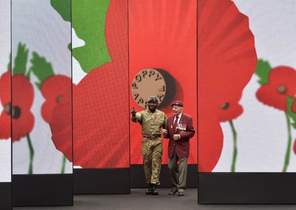 World War II veteran Geoffrey Pattinson (right), 92, stands with former RAF medic Ben Poku, 34, as they view a video installation unveiled by the Royal British Legion's Poppy Appeal in Paternoster Square, London.   Pic: Hannah McKay/PA Wire.