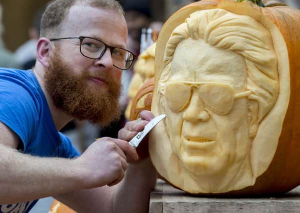 Jamie Wardley, 37, from Sand in Your Eye puts the finishing touch to his pumpkin carving of Leeds United owner Massimo Cellino. Pictures: James Hardisty