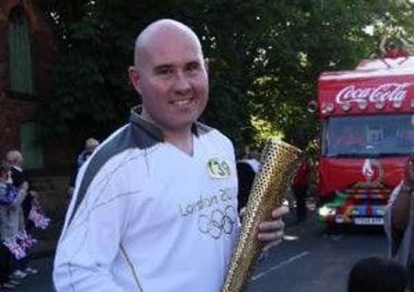 Simon Buckden carrying the Olympic torch.