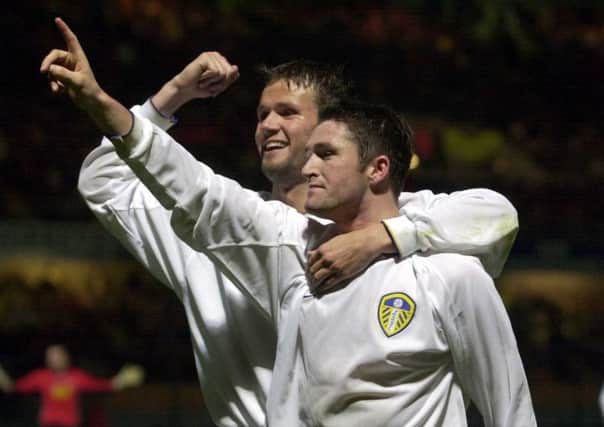 Robbie Keane celebrates his goal with the Leeds fans and Eirik Bakke in Troyes.