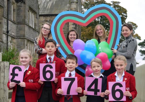 Children hand over a cheque for Â£6,746 to support the heart fund.