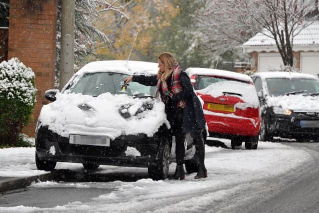 A commuter clears snowfall from her car in Farsley. PIC: Tony Johnson
