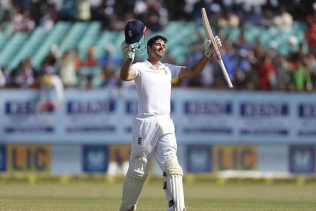 LEADING FROM THE FRONT: England's cricket captain Alastair Cook raises his bat and helmet after scoring a century on the fifth day against India in Rajkot. Picture: AP/Rafiq Maqbool