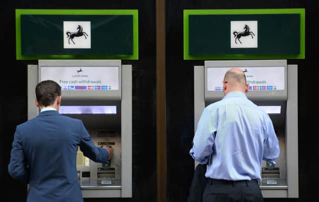 Members of the public using cash machines at a branch of Lloyds Bank in the City of London Photo: Stefan Rousseau/PA Wire