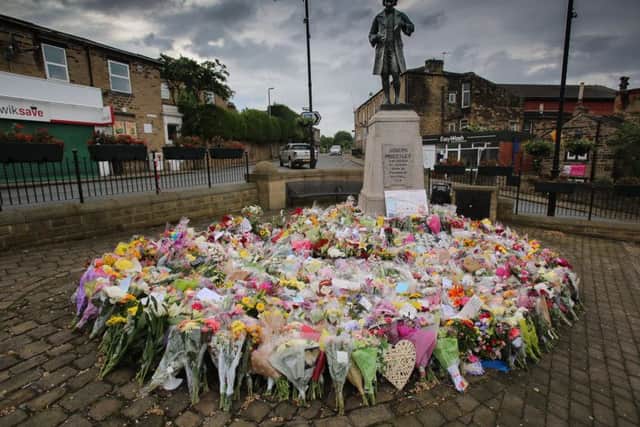 Floral tributes surround the statue of Joseph Priestley in Market Place, Birstall.