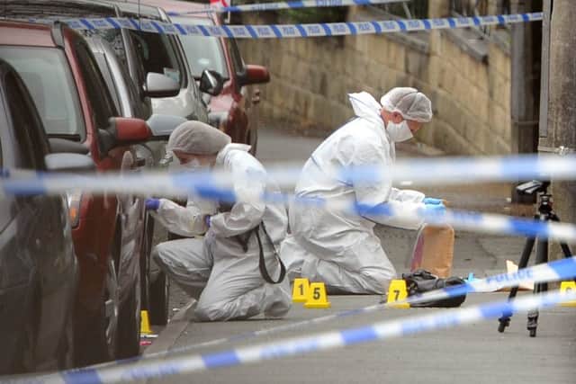 Police forensic officers at work outside Birstall Library on June 16.