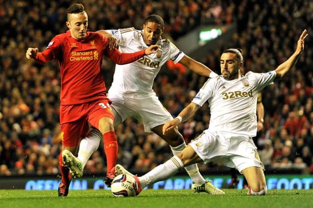 Swansea City's Ashley Williams (centre) and Chico (right) battle for the ball with Liverpool's Samed Yesil (left) during the Capital One Cup, fourth round match at Anfield in 2012.