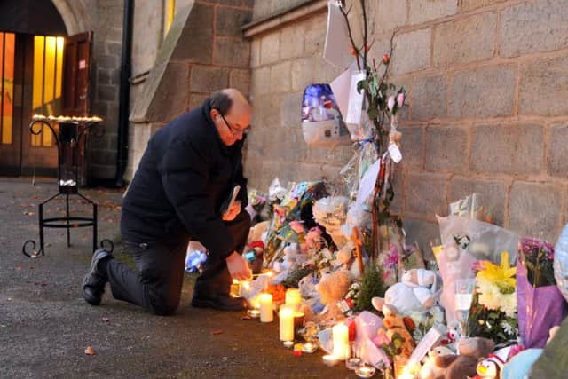 The Rev Paul Crabb, who found the baby boy, lights a candle outside the church in his memory.