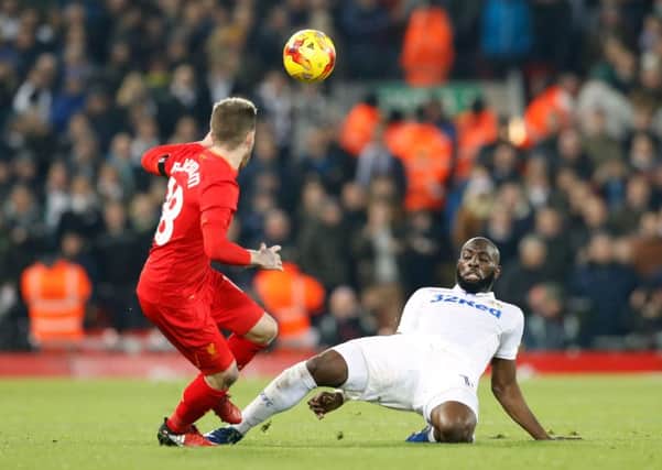 Liverpool's Alberto Moreno (left) and Leeds United's Souleymane Doukara (right) battle for the ball at Anfield. Picture: Martin Rickett/PA