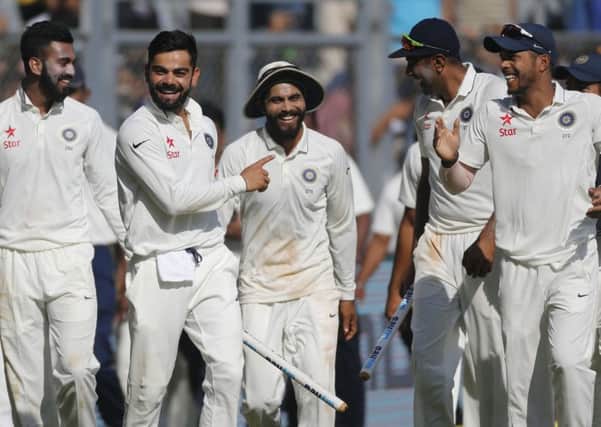 India captain Virat Kohli carries a stump as he celebrates with his players after their win over England