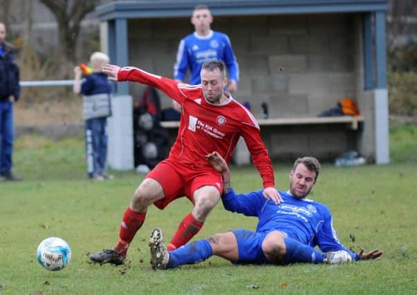Jamie McGeorge, of Stanningley, wins the ball from Lee Swift of Alwoodley Reserves.