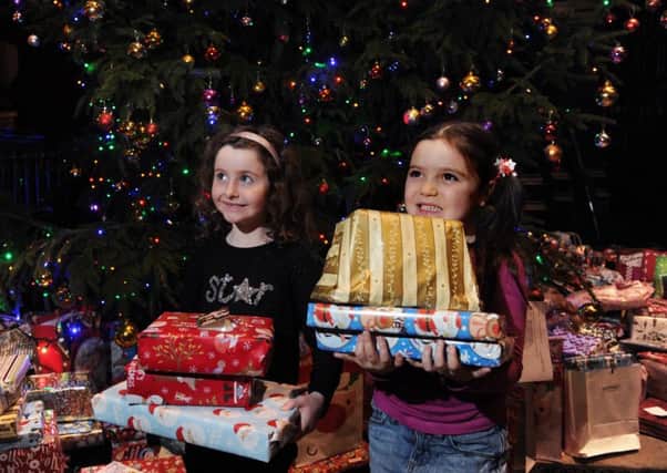 DONATIONS: Six-year-olds Madeleine-Ava Smith and Eimear Langham donating presents for children in hospital at the carol service.