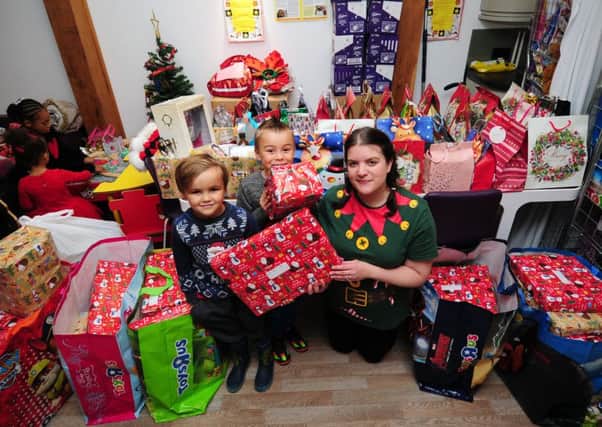 Skye's brothers Harvey and Riley hand over the presents to hospital play specialist Cat Carroll. Picture by Simon Hulme.