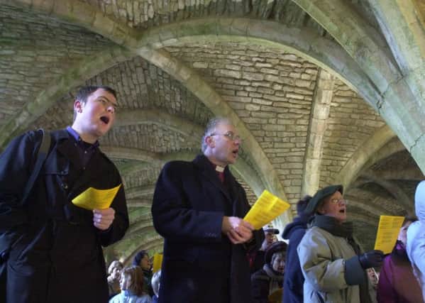 The Rt Revd John Packer (centre) Bishop of Ripon and Leeds joins in the carol singing after walking from Ripon Cathedral to Fountains Abbey on 26th December (Boxing Day) 2000 to take part in the Pilgrimage to Fountains Abbey, also pictured left  is his son Tim.