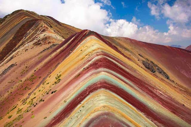A psychedelic rainbow mountain has been discovered in Peru & captured by video drone for the first time.Travellers from the UK climbed to the peak of the mountain which is at 5000 metres above sea level. Photographer Lee Thompson of Flash Pack tours captured the incredible drone footage after trekking 9.3 miles to the peak of the Vinicunca mountain in the South American Andes. Using horses to carry the kit they camped at the foot of the mountain to wait for snow to stop falling before making it to the peak the following day. With the help of expert guides all the Flash Pack group successfully made it to the top and now have amazing drone footage to remember it and give them ultimate bragging rights on social media! Lee said - This really is South Americas best kept secret!