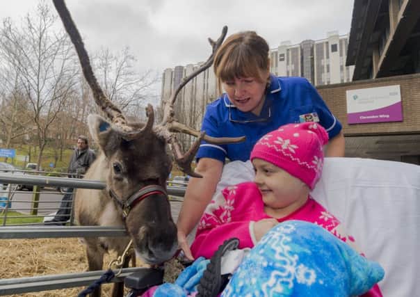Date:20th December 2016. Picture James Hardisty. Visiors, staff and patients had a special surprise outside the Leeds Children's Hospital, Clarendon Wing as part of the hospital's Christmas fair in the form two Reindeers. Pictured Sister Sue Ill, with Heidi Dickinson, aged 8, of Otley.