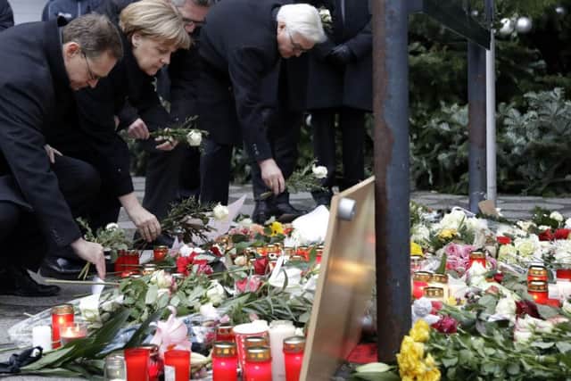 TRIBUTES: German Chancellor Angela Merkel joins the Mayor of Berlin and ministers at the scene.