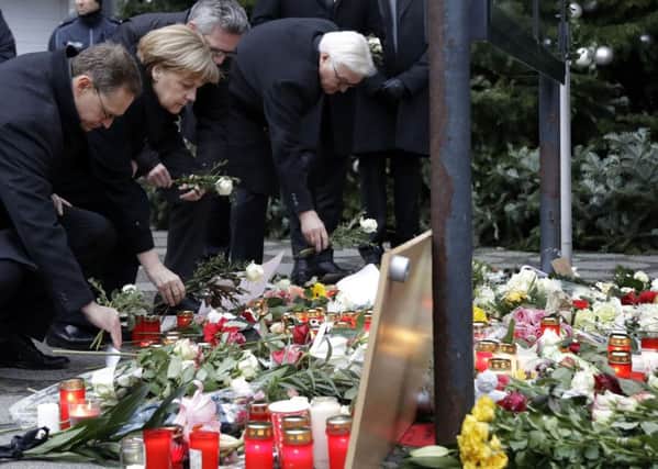 TRIBUTES: German Chancellor Angela Merkel joins the Mayor of Berlin and ministers at the scene.