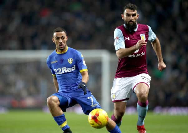 Leeds United's Kemar Roofe (left) and Aston Villa's Mile Jedinak (right) battle for the ball