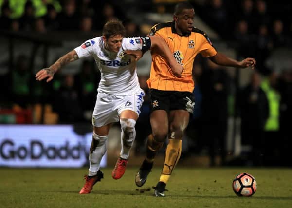 Cambridge's Uche Ikpeazu and Leeds United's Liam Cooper (left) battle for the ball. (Picture: PA)