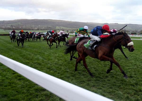 Old Guard ridden by Harry Cobden (red cap) on their way to victory in the StanJames.com Greatwood Hurdle during day three of The Open at Cheltenham in November 2015.
