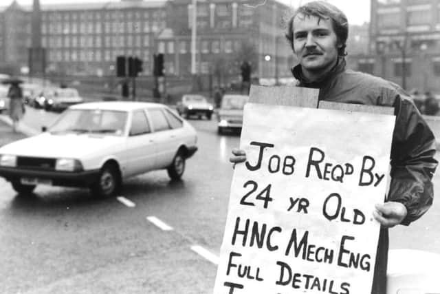 Leeds, 1980s  From the traffic island near the International Pool in Leeds, Frank Howarth holds aloft his sign asking for work ---- in the hope that some passing driver can solve his dilemma.