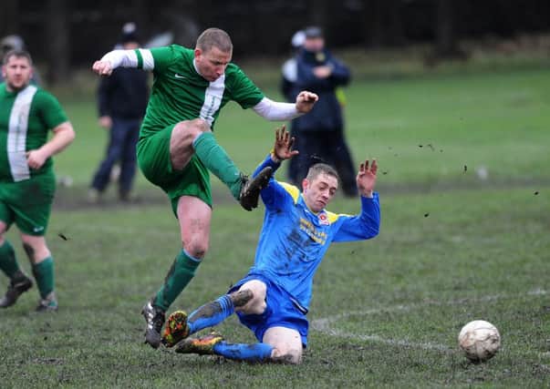 East Leeds' Paul Cuthbertson slides in on New Pudsey's Lee Knowles. PIC: Jonathan Gawthorpe