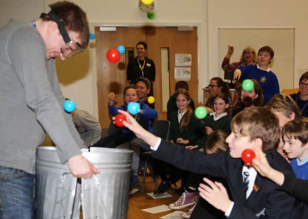 PHYSICS: Dr Samuel Gregson collecting particles from the students.