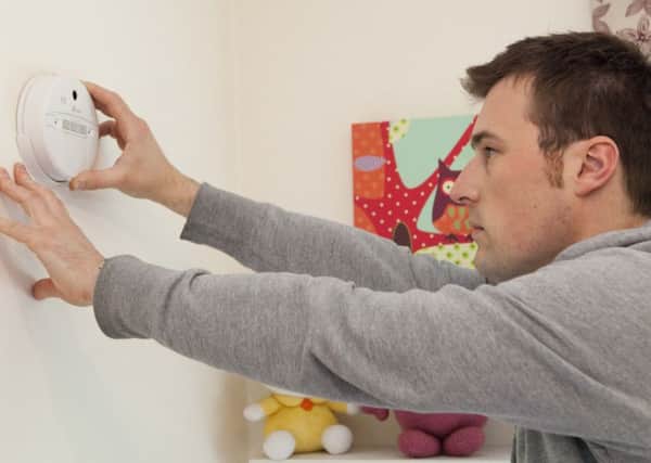 A carbon monoxide alarm being fitted.