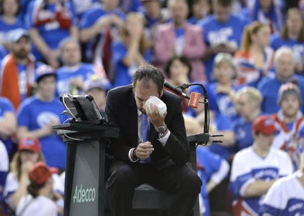 Umpire Arnaud Gabas, of France, holds ice to his face after being hit in the eye by a ball.
