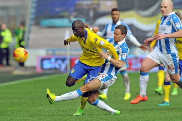 Leeds United's Mo Barrow is tackled by Huddersfield Town's Chris Lowe.
