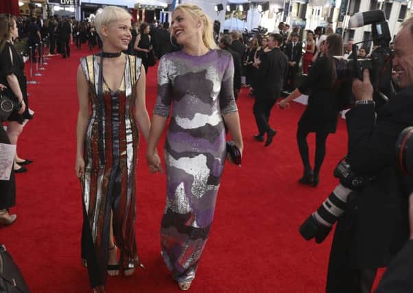 WOMEN MARCH TOGETHER: Even on the red carpet, in very shiny dresses - Michelle Williams, left, and Busy Philipps arrive at the 23rd annual Screen Actors Guild Awards in Los Angeles. (Photo by Matt Sayles/Invision/AP)