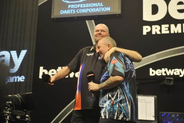 Phil Taylor leaves the stage with Raymond van Barneveld.