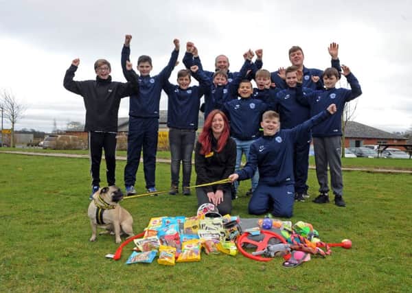 Cobie Yates and his teammates at Wortley FC under 12s pass on a hamper full of treats to Charlotte Allen at the Dogs Trust on York Road. Picture Tony Johnson.
