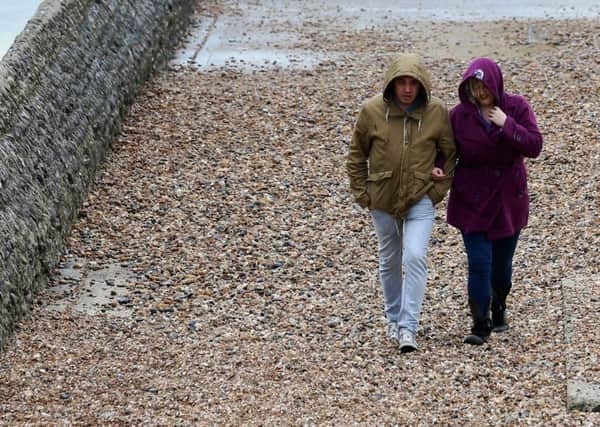 A couple walk along a sea wall ahead of the predicted Storm Doris. PIC: PA