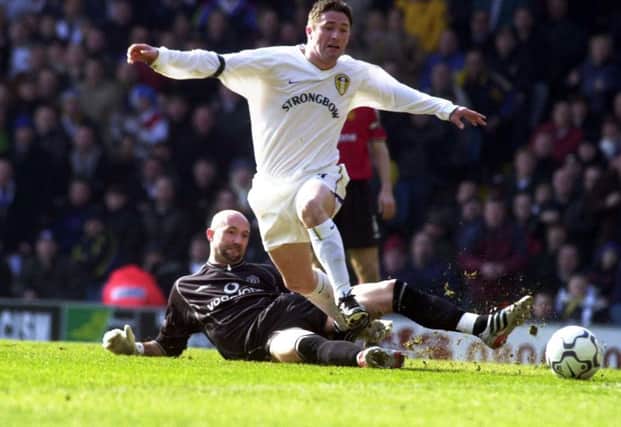 Leeds United striker Robbie Keane is tackled by Manchester United's Fabien Barthez.