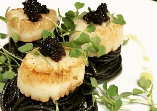 Hand fished scallops on cuttlefish ink spaghetti, garnished with caviar.