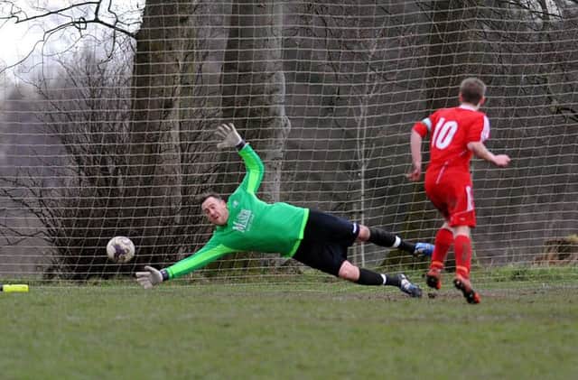 Josh Thornton scores a late equaliser from the penalty spot for Shire past Drighlington goalkeeper Ivan Willis. PIC: Steve Riding